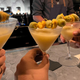 Three glasses being held up in a toast at the bar